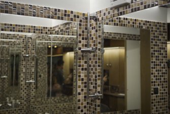 Koupelna se zrcadly a mozaikovými kachličkami.